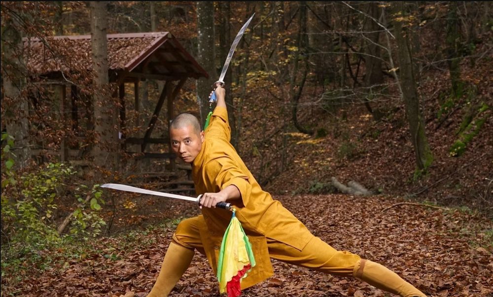 Meister Shi Yan Lu in einer Kampfkunst-Form mit Schwertern